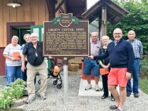 Photograph of community members around the Liberty Center sign.
